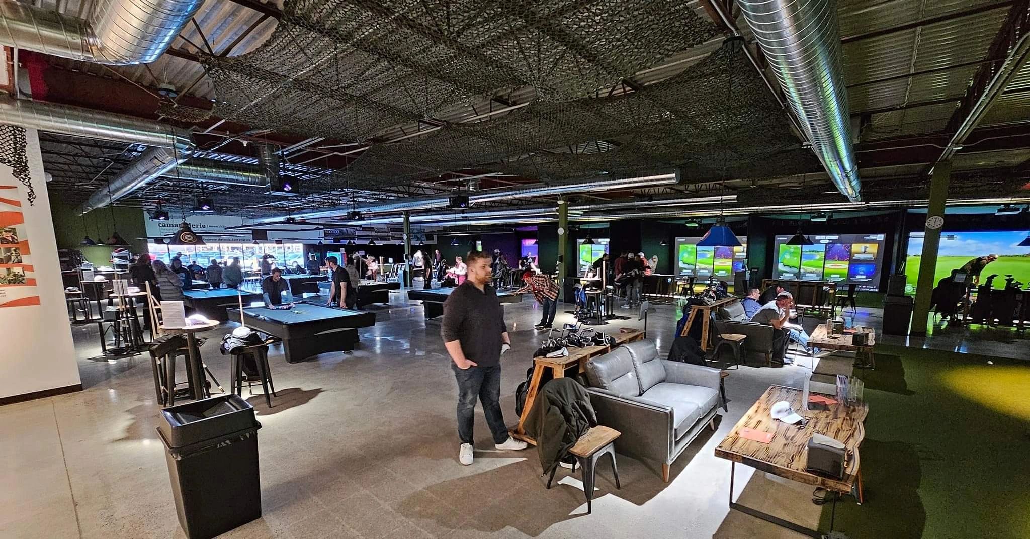 Inside Canteen with golf simulators, seating, and billiards